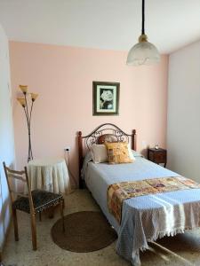 a bedroom with a bed and a chair and a lamp at Casa Ti Mielga in Ayoó de Vidriales