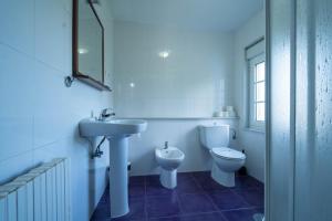 a white bathroom with a sink and a toilet at Apartamentos Castello in Cartavio +85 photos