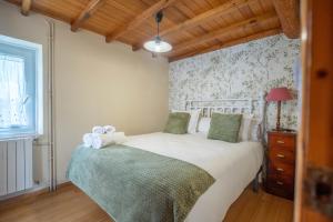 a bedroom with a white bed with a wooden ceiling at Apartamentos Castello in Cartavio