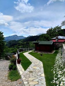 a walkway leading to a building with mountains in the background at Wild Life Chalets in Rafína