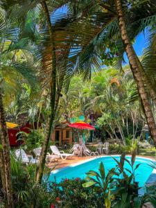 a resort with a swimming pool and palm trees at Cajibá Imbassai in Imbassai