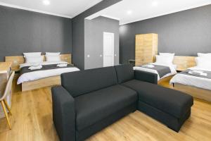 a living room with two beds and a couch at Hotel Caucasus Borjomi in Borjomi