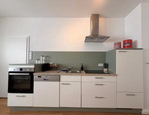 a kitchen with white cabinets and a stove top oven at Markt-Quartier in Nierstein