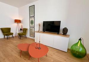 a living room with a television and a table and chairs at Markt-Quartier in Nierstein