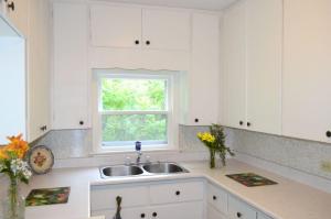 a white kitchen with a sink and a window at Still Point Lodge in Deep Brook +212 photos