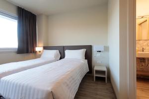 two beds in a hotel room with white sheets at alla campagna in Trissino