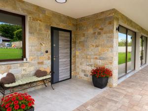 a patio with a stone wall and a door with flowers at Gracia House in Mogilovo