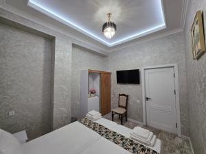 a hotel room with two beds and a chair at Bekh House SAM in Samarkand +20 photos