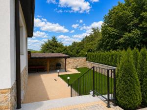 a porch of a house with a fence and a garden at Gracia House in Mogilovo