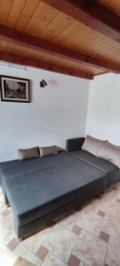 a large bed in a room with a wooden ceiling at Apartma Dajana in Lokve