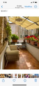 a balcony with a couch and an umbrella at La Magnolia in Orvieto