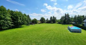 a large grass field with a pool in the middle of it at Domki Lilia Sarbinowo in Sarbinowo