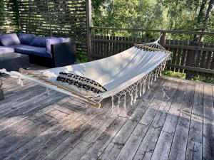 a hammock on a deck with a couch at The Archipelago Hideaway in Vaxholm