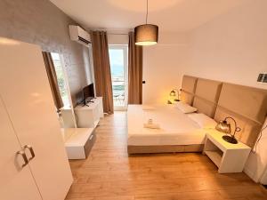 a bedroom with a bed and a tv and a window at Diamond Prestige Hotel in Sarandë
