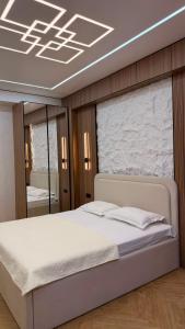 a bedroom with a white bed and a mirror at Capital city in Shymkent