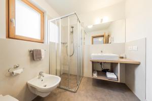 a white bathroom with a sink and a shower at Hotel Steinrösl in San Cassiano +75 photos