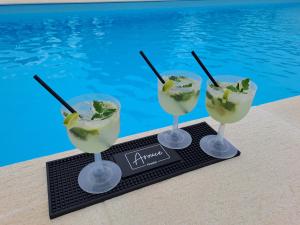 Zwei Cocktails auf einem Tablett neben einem Swimmingpool in der Unterkunft ArouceHostel in Lousã