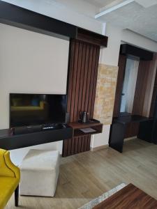 a living room with a tv and a yellow chair at Aurora Kopaonik in Raška