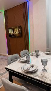 a table with chairs and plates and glasses on it at Capital city in Shymkent +8 photos