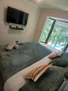 a bedroom with a large bed with a flat screen tv at Departamento en Pucón in Pucón +19 photos