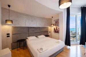 a bedroom with a large white bed and a balcony at Diamond Prestige Hotel in Sarandë +34 photos
