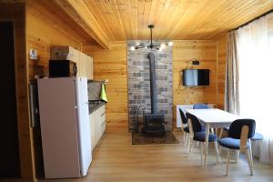 a kitchen with a refrigerator and a table with chairs at Cottage Mildiani in Mestia