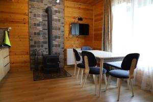 a dining room with a fireplace and a table and chairs at Cottage Mildiani in Mestia
