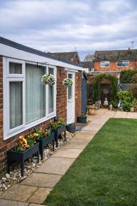 a house with some plants on the side of it at Rosie House 3 bedroom House in Sandbach with Parking in Sandbach