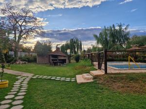 a backyard with a pool and a table and a ping at Cabañas El Sauce in Albardón