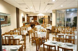 a dining room with white tables and chairs at Hotel Filoxenia Beach in Leptokarya