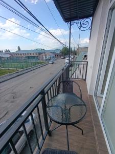 a chair on a balcony with a view of a street at VSt GRAND HOTEL in Ninotsminda