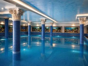 a swimming pool in a building with columns at Shala Resort & SPA in Durrës