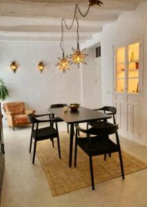 ein Esszimmer mit einem schwarzen Tisch und Stühlen in der Unterkunft Zarcillo in Olvera