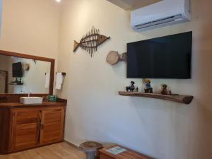 a bathroom with a flat screen tv on the wall at Chalé Jacuzzi Fortim in Fortim