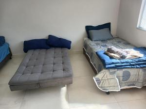 a room with a bed and a couch in it at COLOFT - Quarto 4 Hospedagem rápida ou Sala de reunião in Anápolis