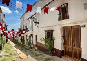 eine Straße mit rot-weißen Fahnen und ein Gebäude in der Unterkunft Zarcillo in Olvera