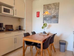 a kitchen and dining room with a wooden table and chairs at Texel-De Koog 116 in De Koog