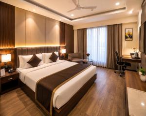 a hotel room with a large bed and a desk at Hotel Aviora Plaza By Almati Group Near IGI Delhi Airport With - Free Airport Pickup in New Delhi +2 photos