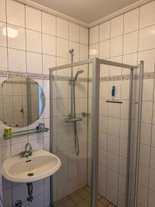 a bathroom with a sink and a shower with a mirror at Texel-De Koog 116 in De Koog