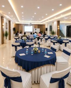 a conference room with blue tables and white chairs at Hotel Aviora Plaza By Almati Group Near IGI Delhi Airport With - Free Airport Pickup in New Delhi