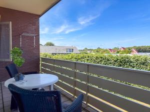 a patio with a white table and chairs on a balcony at Texel-De Koog 116 in De Koog +7 photos