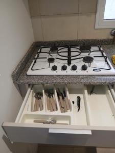 a stove top oven sitting under a counter in a kitchen at Punto Sur Apart in Río Cuarto