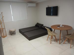 a living room with a bed and a table at COLOFT - Quarto 4 Hospedagem rápida ou Sala de reunião in Anápolis +22 photos