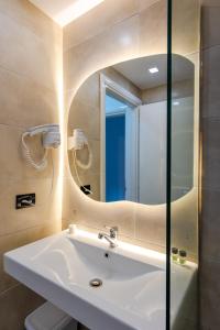 a bathroom with a sink and a mirror at Diamond Prestige Hotel in Sarandë