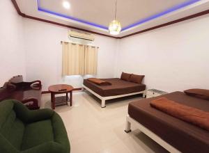 a bedroom with two beds and a couch and a table at Gn story love บ้านเกาะล้าน 小珊瑚岛班泳池别墅 in Ko Larn