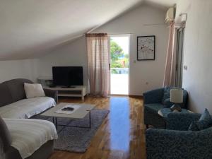 a living room with a couch and a tv at Apartments Maria in Umag