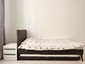 a bedroom with a bed and a white wall at City View Apartment in Mitrovica