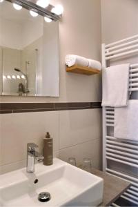 a bathroom with a sink and a mirror and towels at Boutique-Hotel "Stilvoll" in Andernach