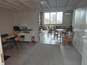 ein Wohnzimmer mit Tischen und Stühlen und ein Zimmer mit in der Unterkunft Köima Loft in Kõima