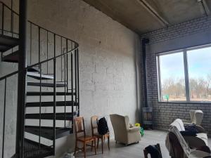 ein Wohnzimmer mit Wendeltreppe und Stühlen in der Unterkunft Köima Loft in Kõima + 1 Foto